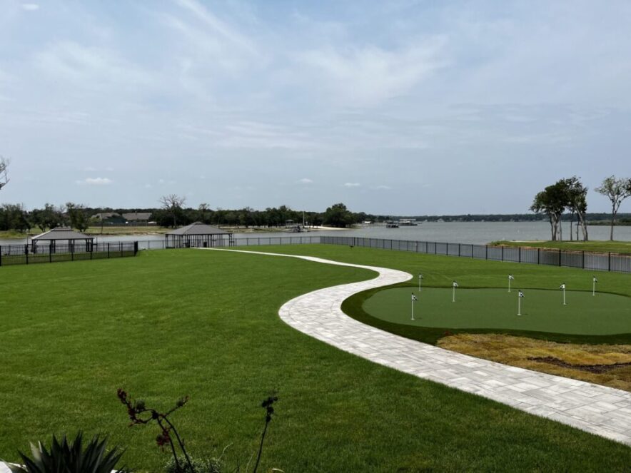 A manicured lawn and putting green near waterfront — professional lawn maintenance by Ellis Landscape Services